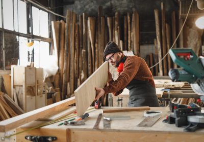 Attentive,Adult,Woodworker,Examining,Rasped,Wooden,Board,While,Working,In